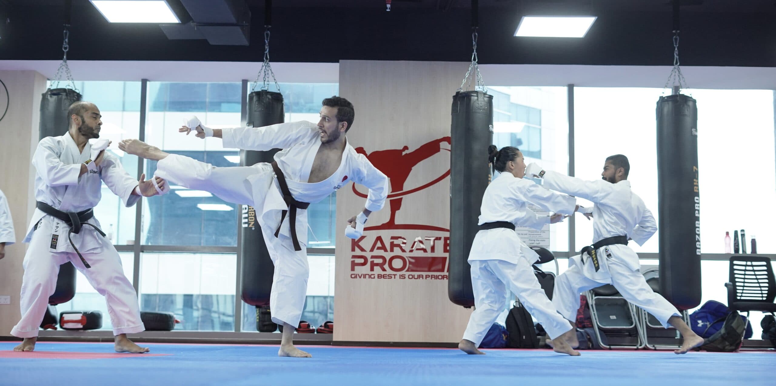 A Karate Pro student delivering a high kick on the training bags in the dojo