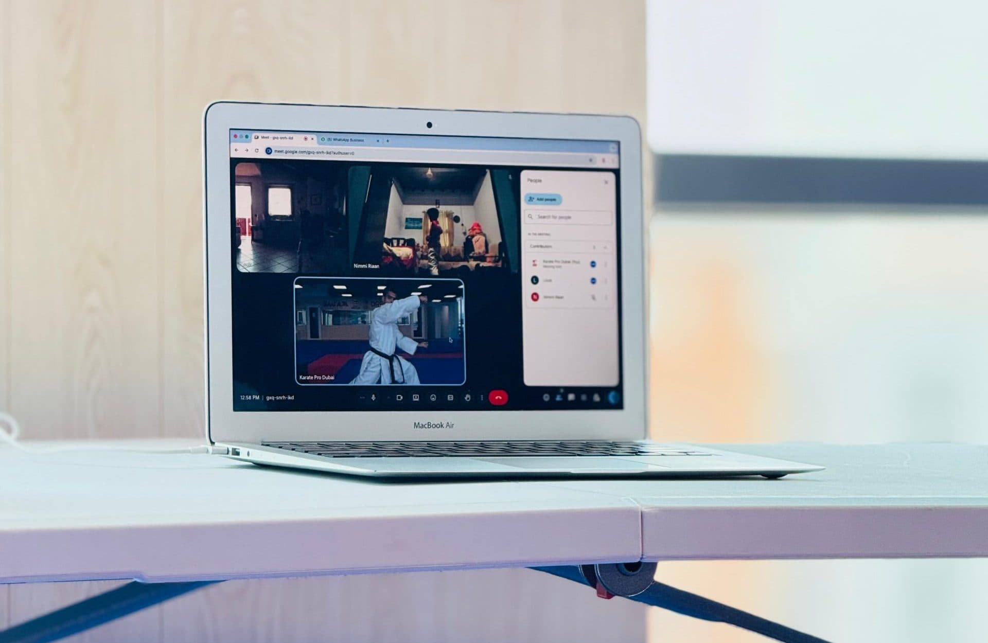 A laptop showing a live online karate class in progress