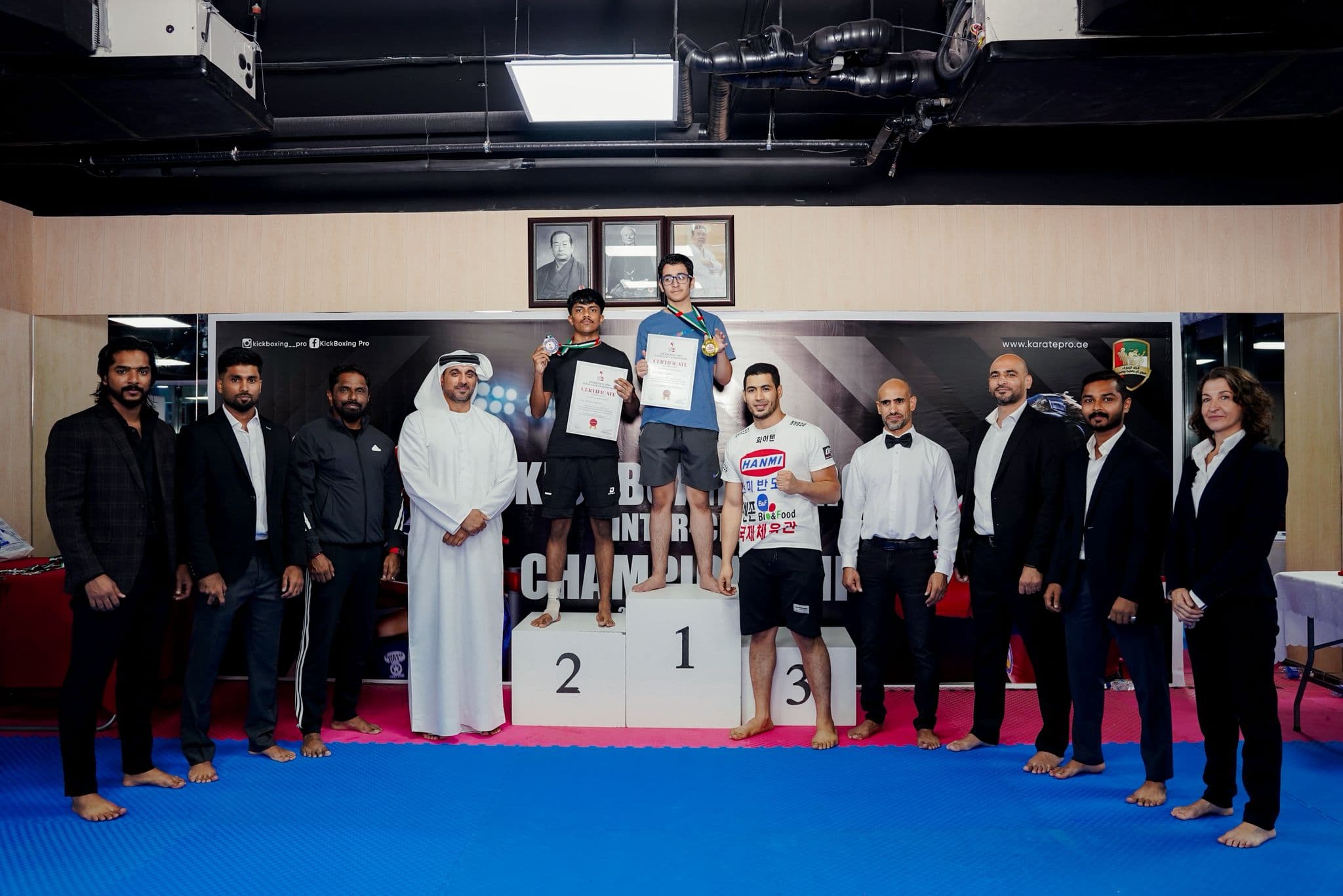 Medallists on the podium with certificates alongside officials at the Kickboxing pro inter club championship 2025