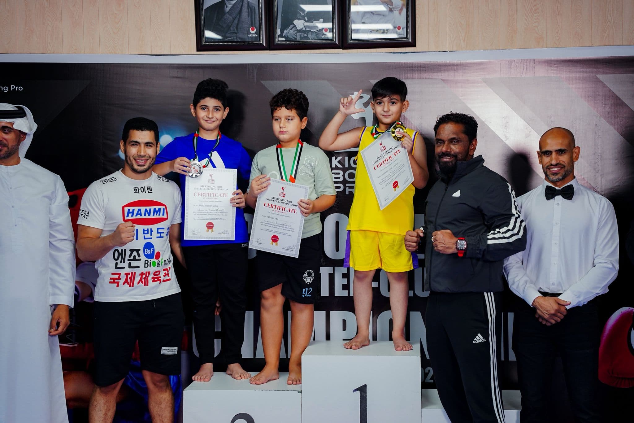 Junior medallists holding certificates with officials at the Kickboxing pro inter club championship 2025