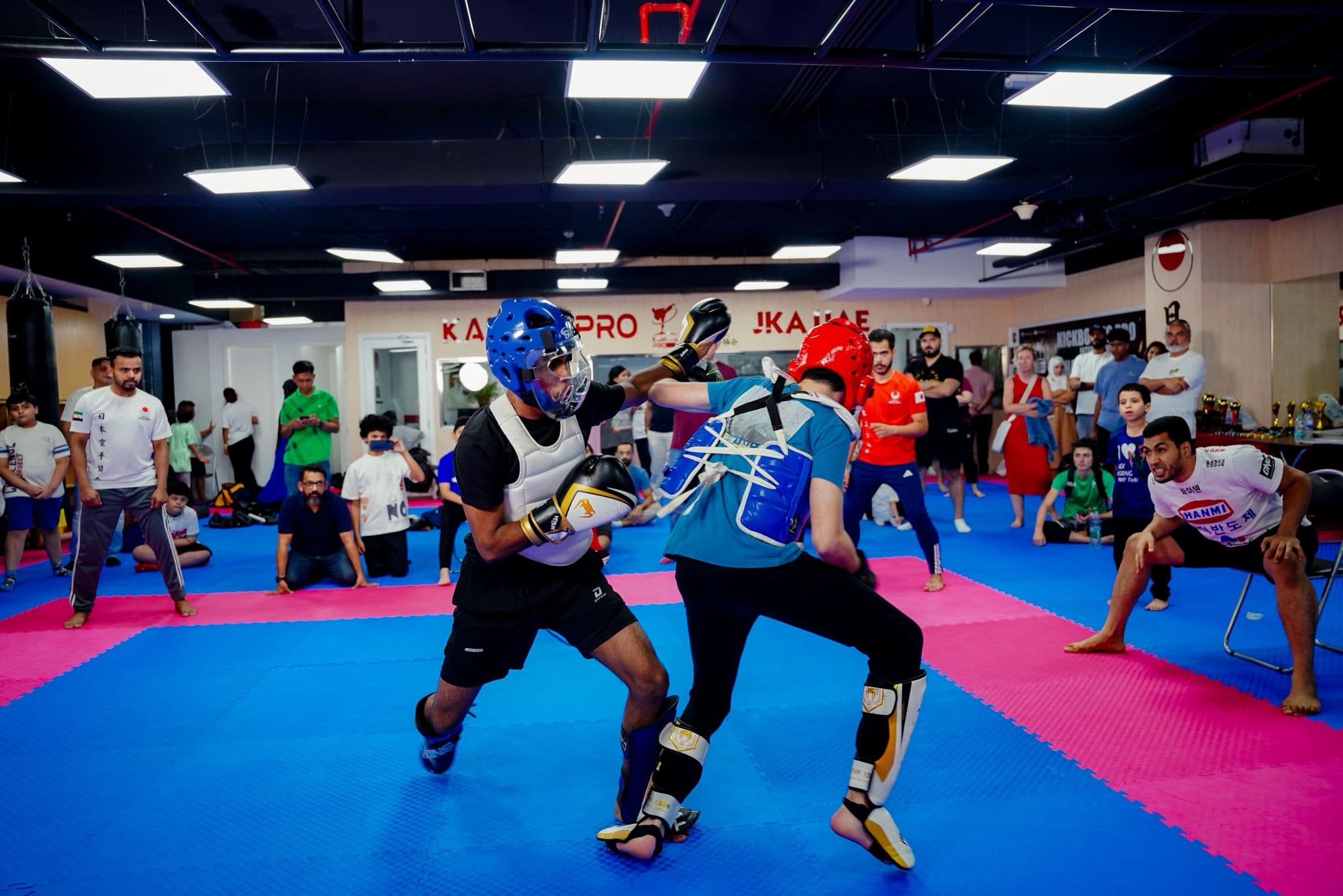 Two young kickboxers in head guards exchanging kicks during a bout at the inter club championship 2025