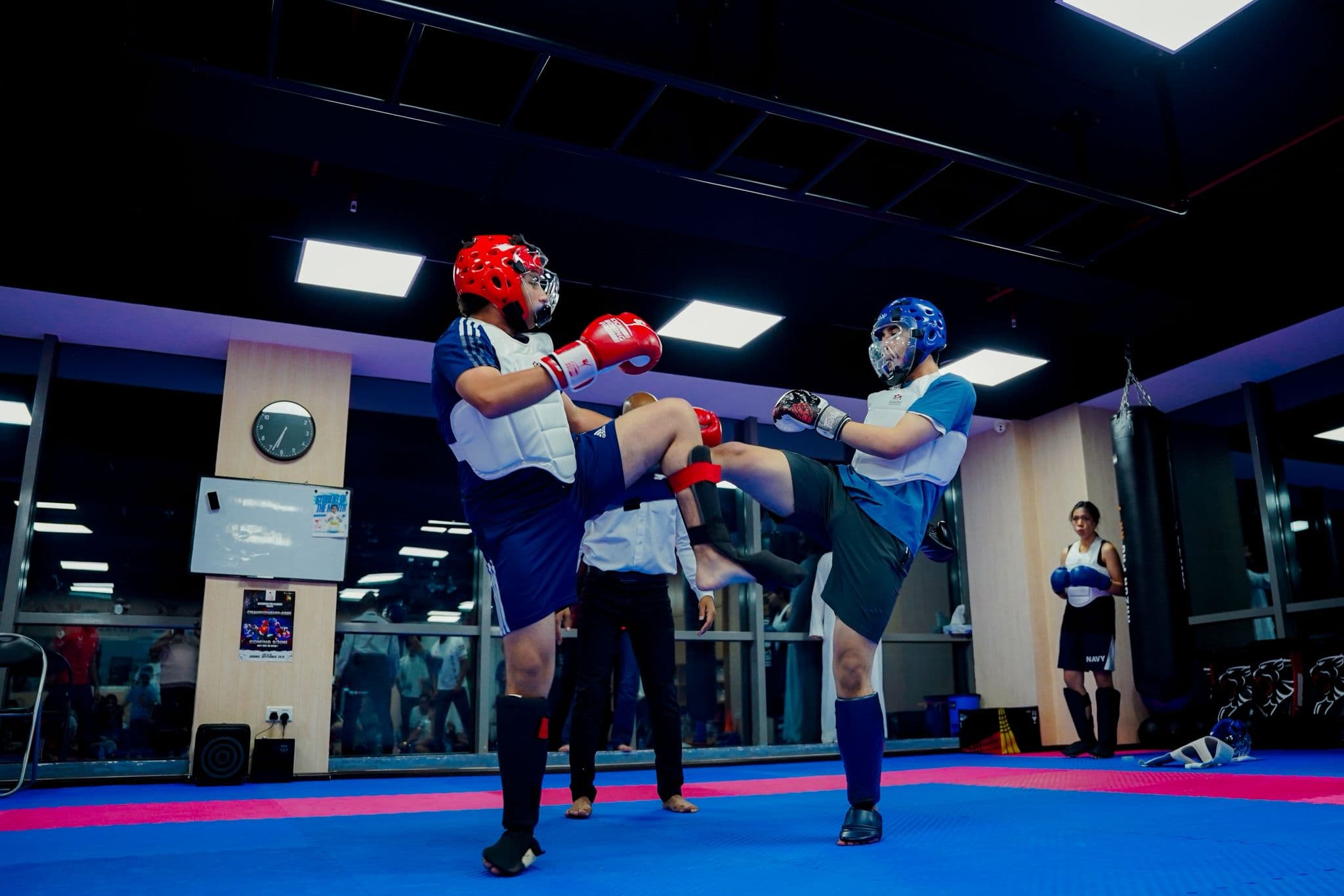 Two kickboxers trading kicks under the referee's watch at the inter club championship 2025