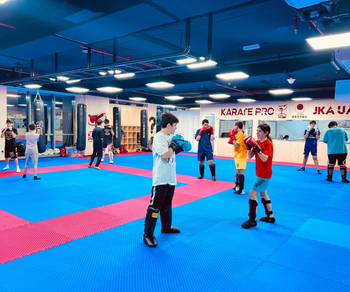 Kids and teens spread across the mats during a busy kickboxing class
