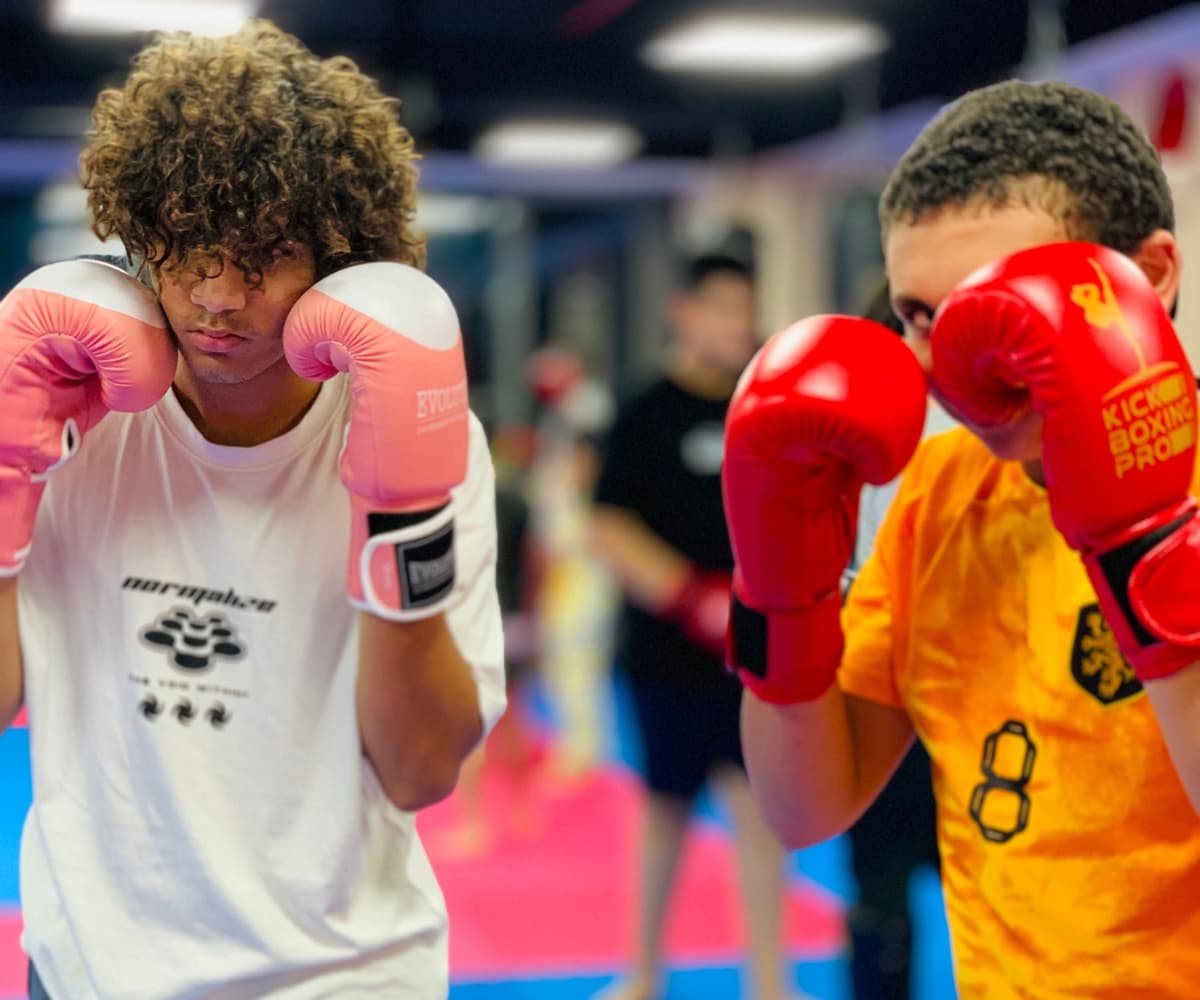 Two teenage boys in red gloves holding tight guards close to the camera