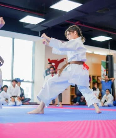 Young girl in brown belt holding a deep front stance during kata practice