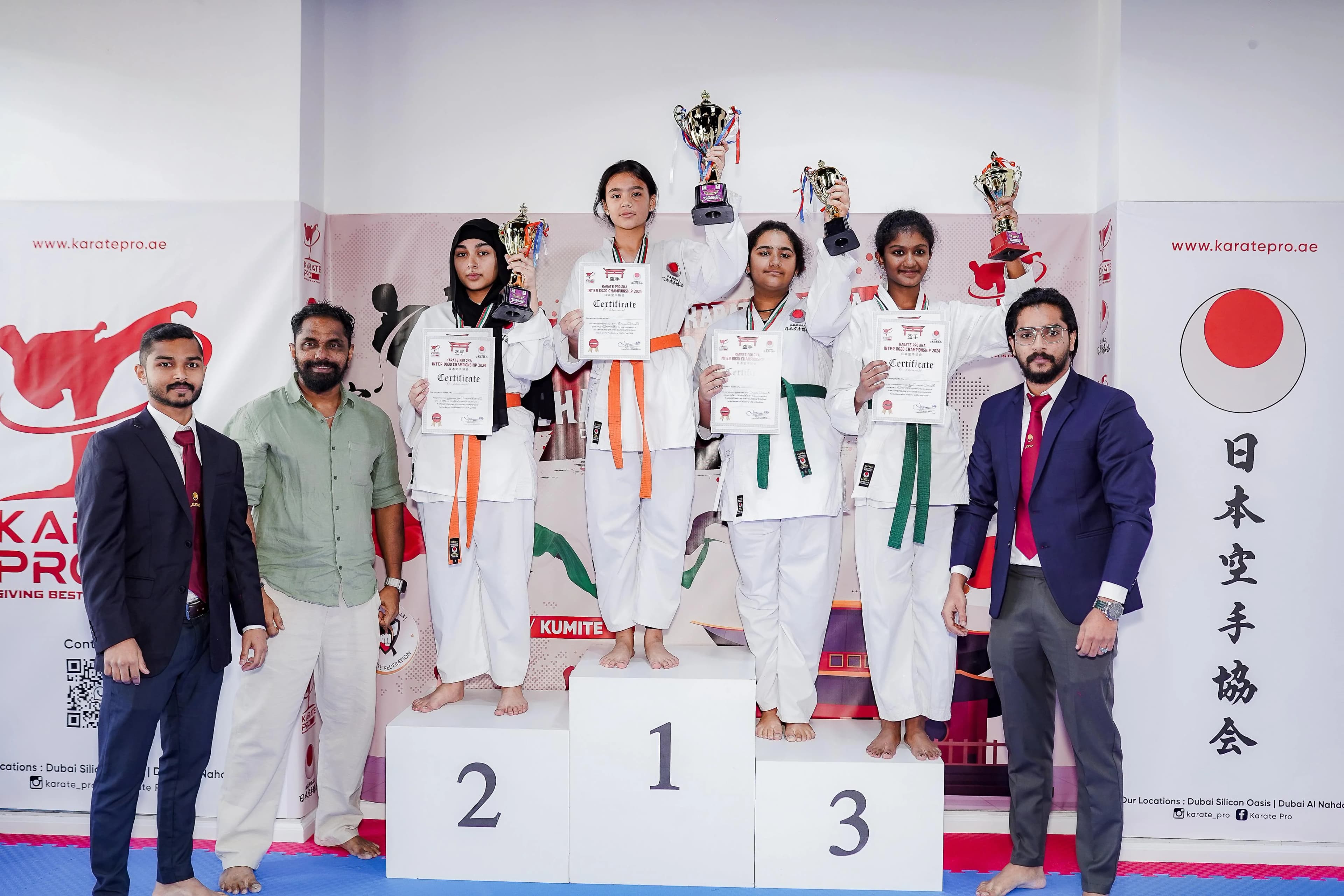 Winners on the podium with trophies and certificates at the inter-dojo karate championship 2024