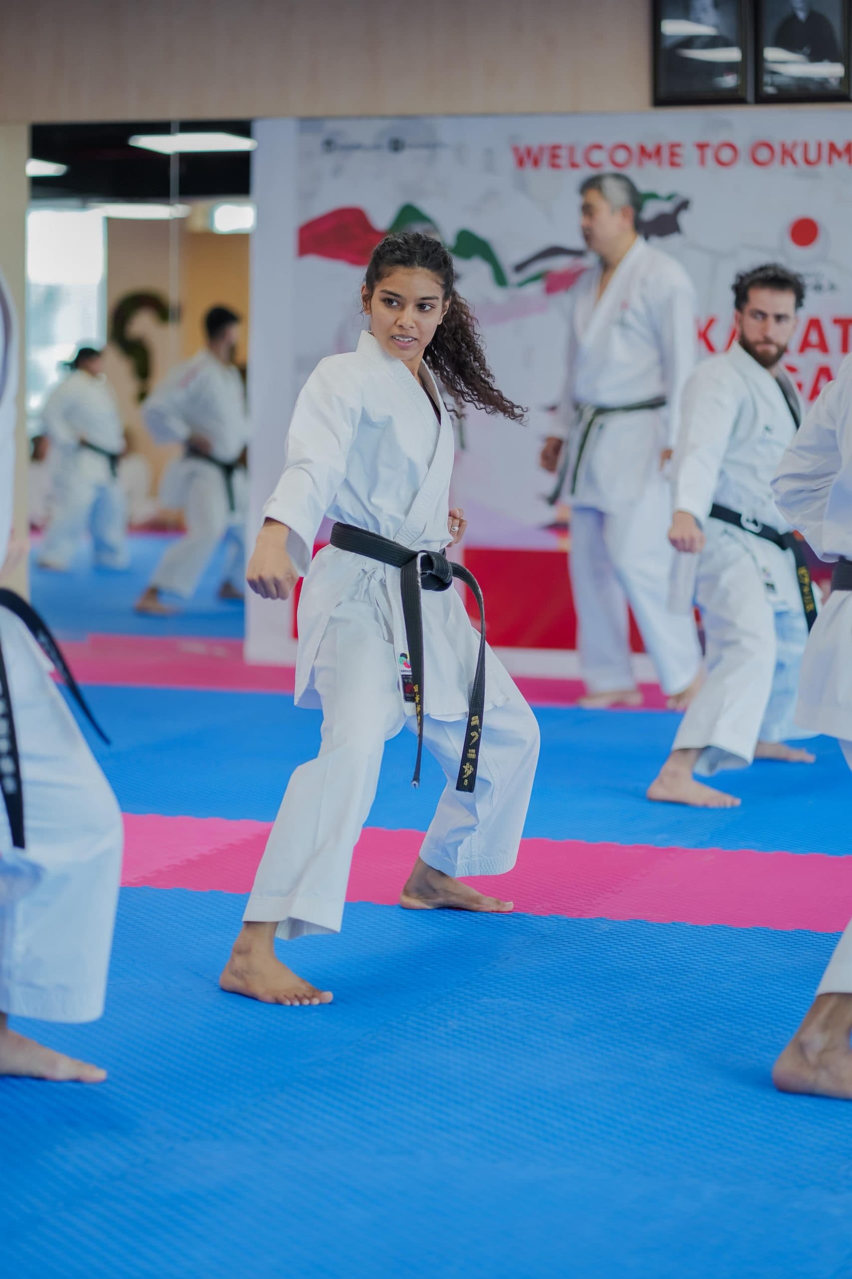 Adult karate class practising kata together on the mats