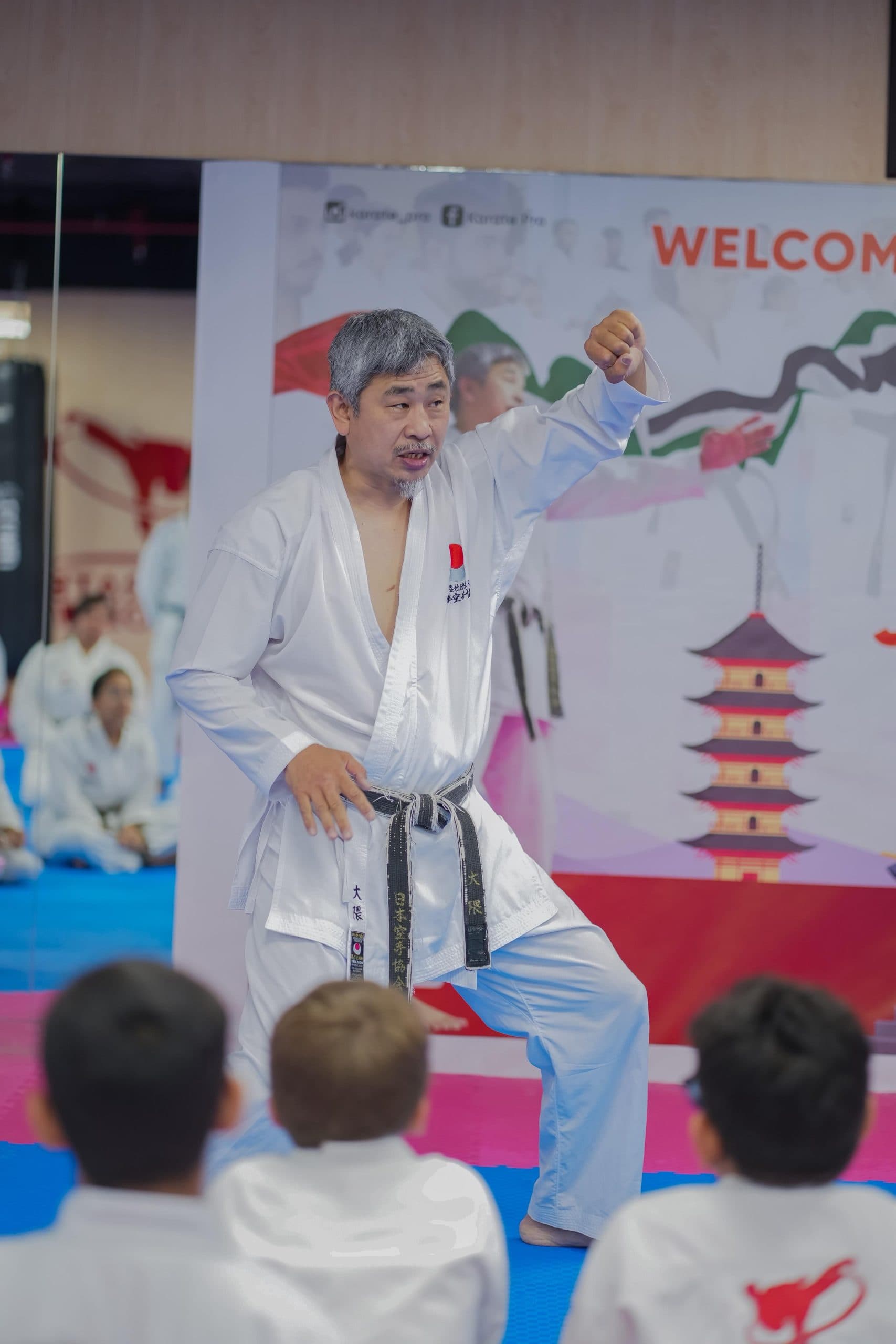 An adult and children training karate side by side in the same class