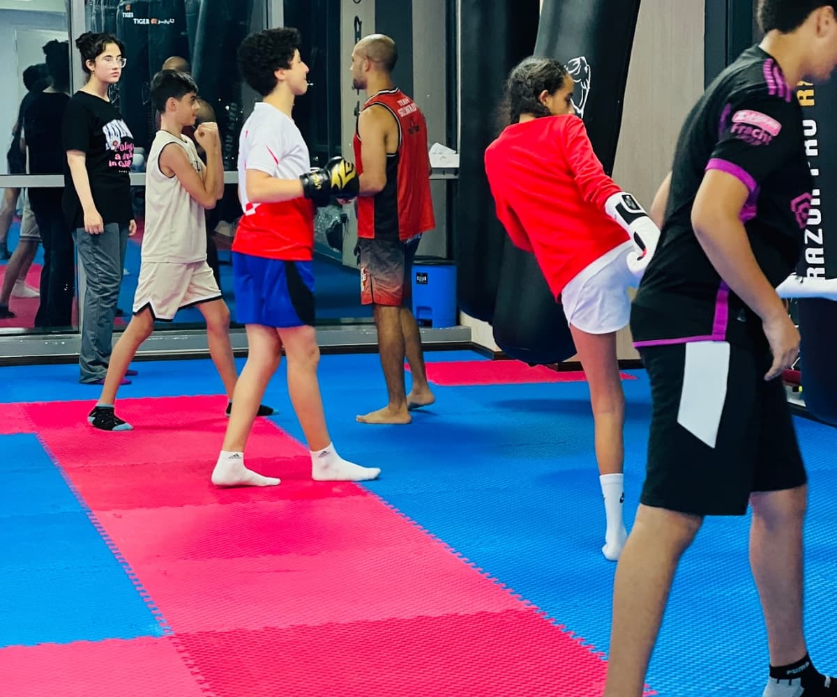 Students working through sparring drills in pairs during a kickboxing class