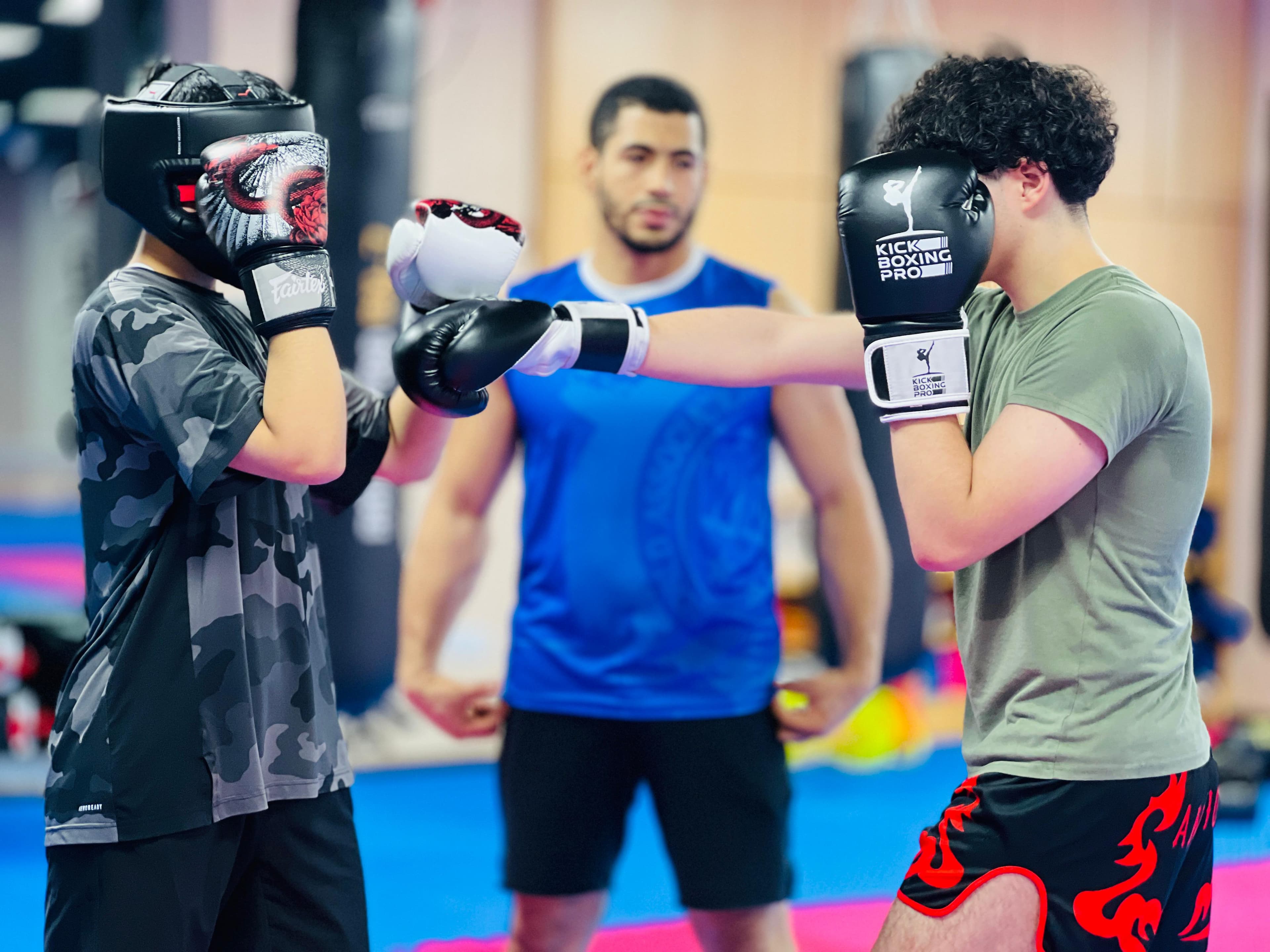 Students paired up for a pad-holding drill during kickboxing class