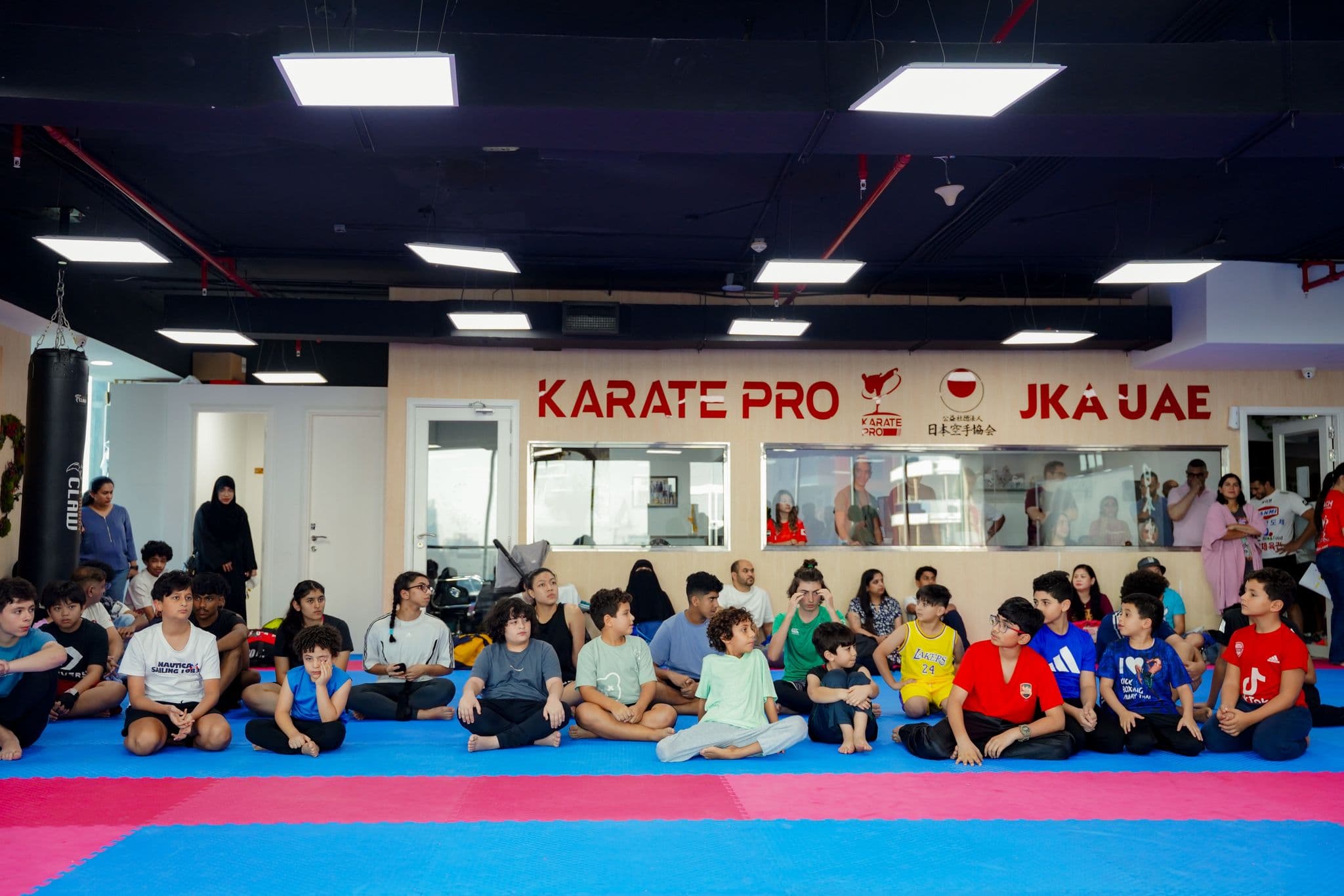 Kickboxing students seated together at a training seminar in the dojo