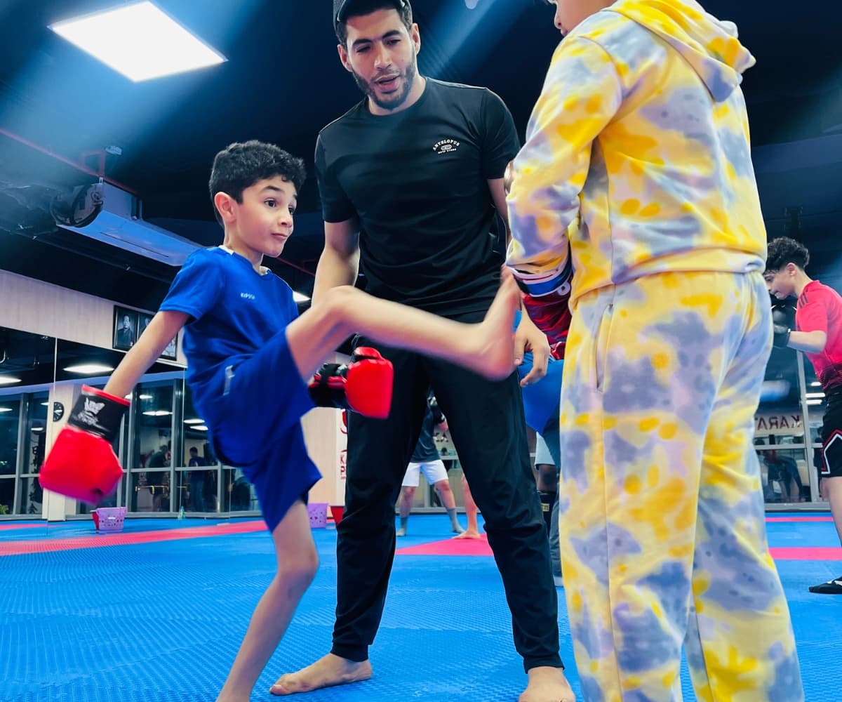 Coach running a pad drill with a young child