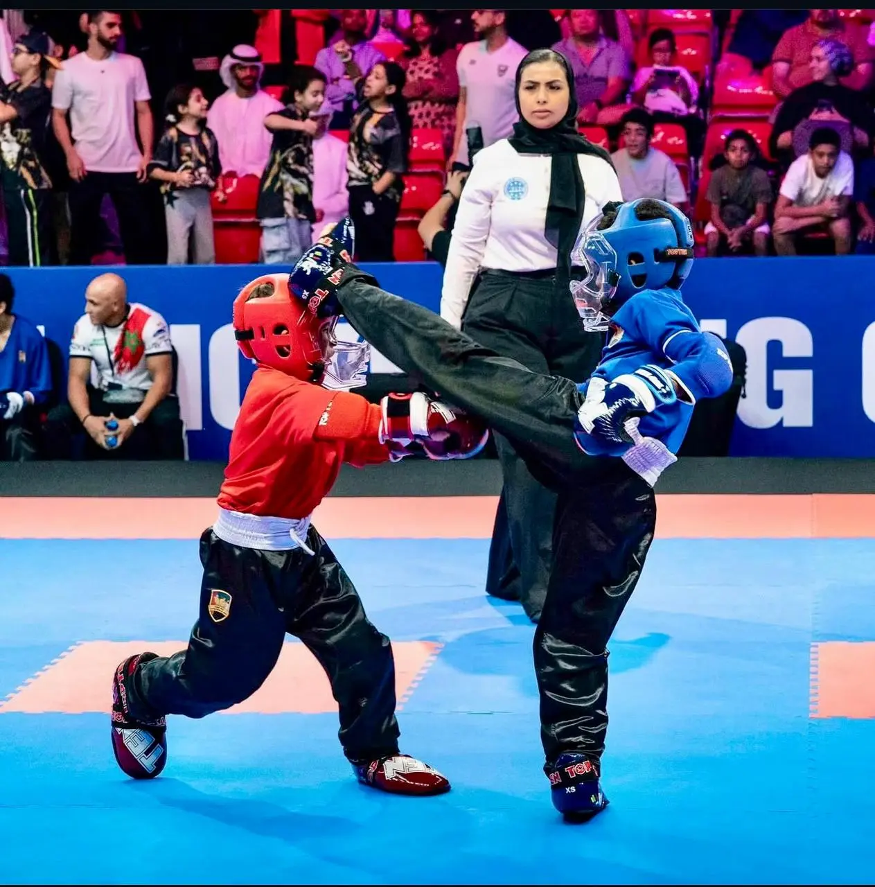 Kids sparring in protective gear during kickboxing class