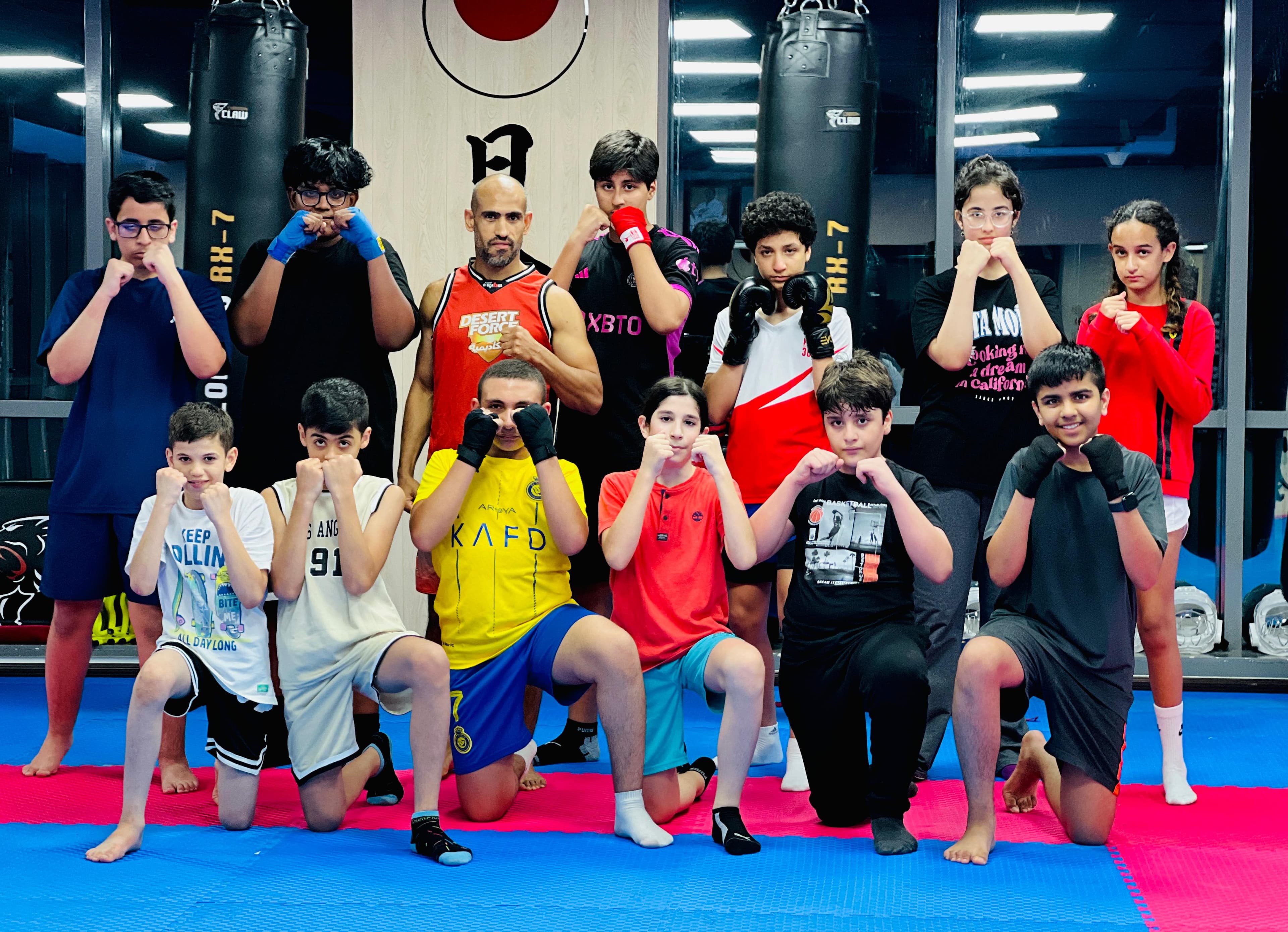 Teens kickboxing class posing together in their gloves