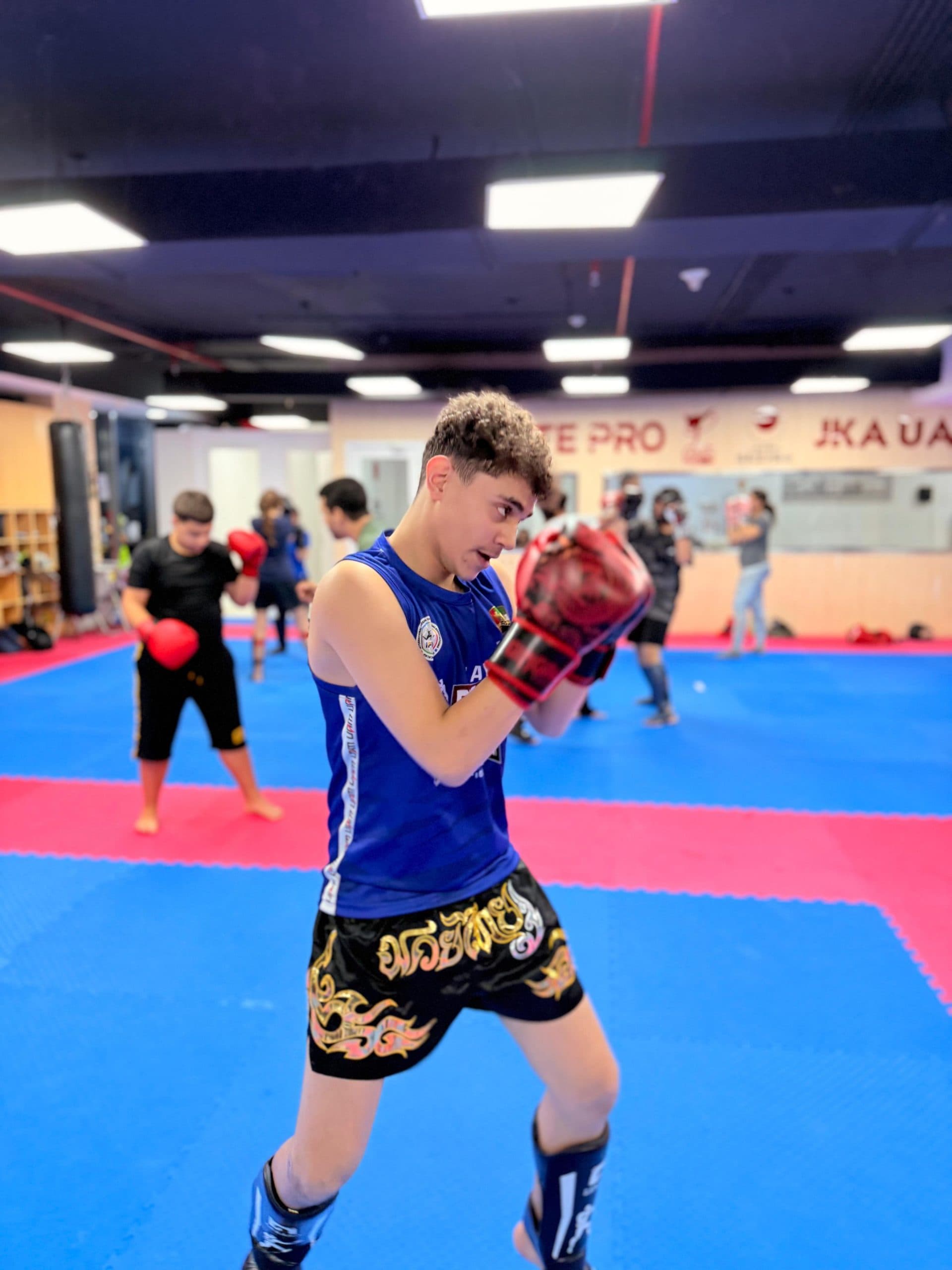 Teenager holding a guard stance during kickboxing class