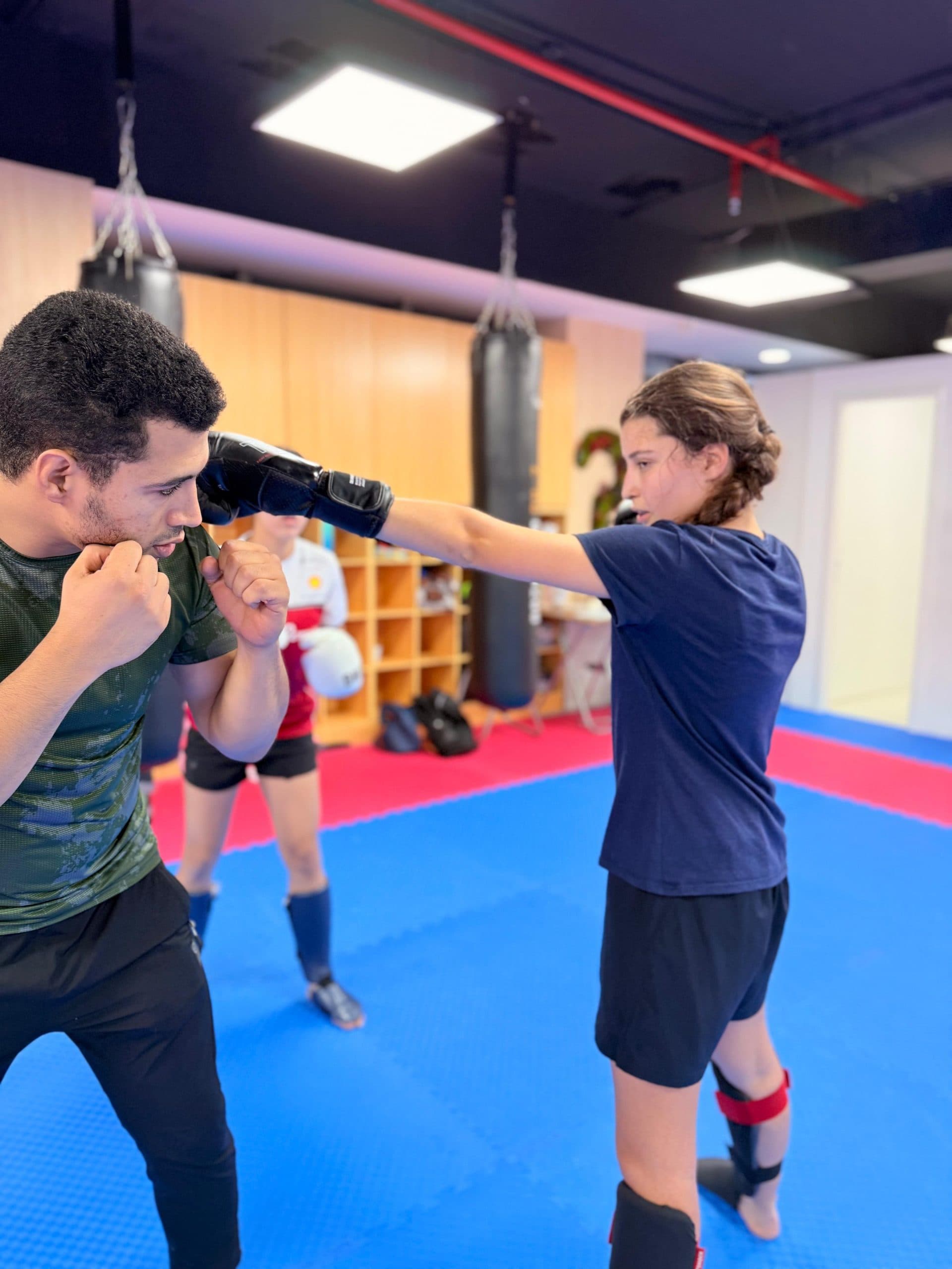 Teenager striking focus pads during a kickboxing drill